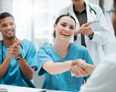 Buy stock photo Shot of a young female doctor shaking hands with a colleague at work
