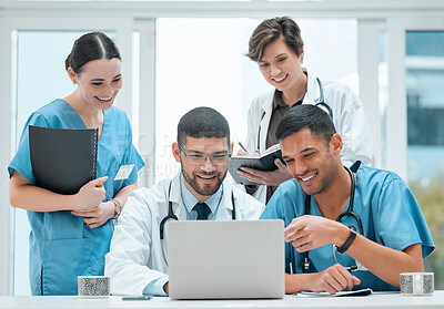 Buy stock photo Shot of a group of doctors using a laptop together at work