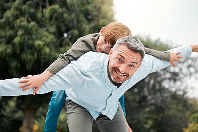 Buy stock photo Shot of a man piggybacking his son at the park