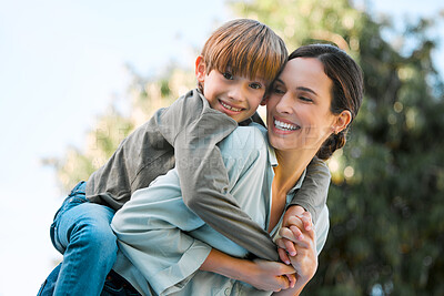 Buy stock photo Shot of a beautiful woman piggybacking her son at the park