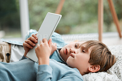 Buy stock photo Shot of two brothers using a tablet at home