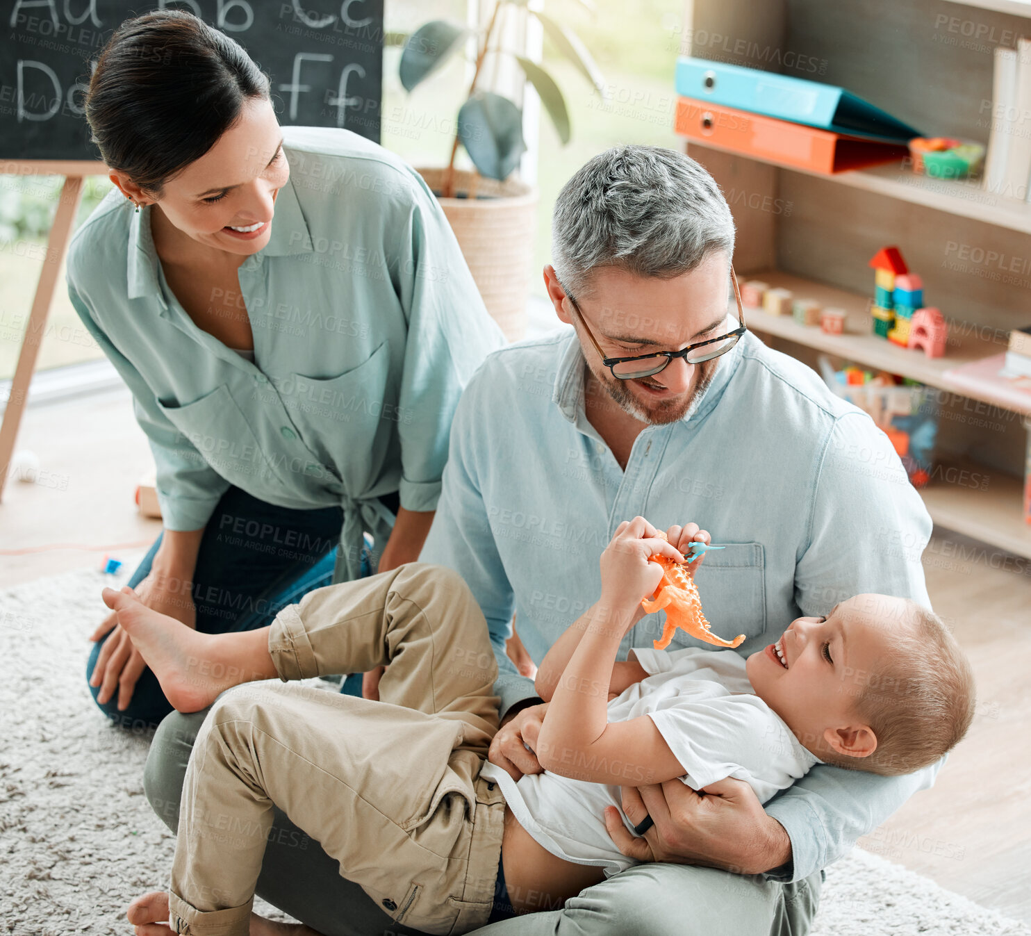 Buy stock photo Family, child and play with toy dinosaur or hug for bonding, teaching and learning of animals history in living room. Parents, boy and embrace with communication for plastic reptiles, game and house