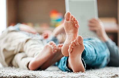Buy stock photo Shot of two unrecognizable brothers using a tablet at home