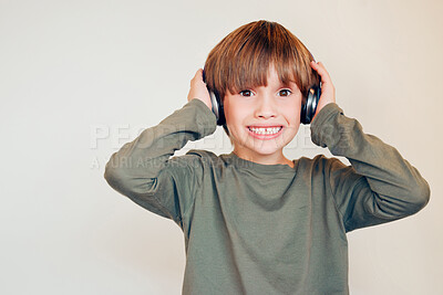 Buy stock photo Smile, portrait and child in studio with headphones for sensory regulation with autism spectrum. Happy, mockup and boy kid with noise cancelling technology for stimulation control by white background