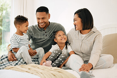 Buy stock photo Shot of a beautiful young family talking and bonding in bed together