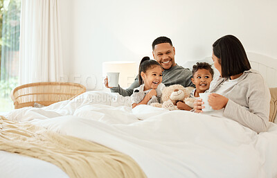 Buy stock photo Shot of a beautiful young family talking and bonding in bed together