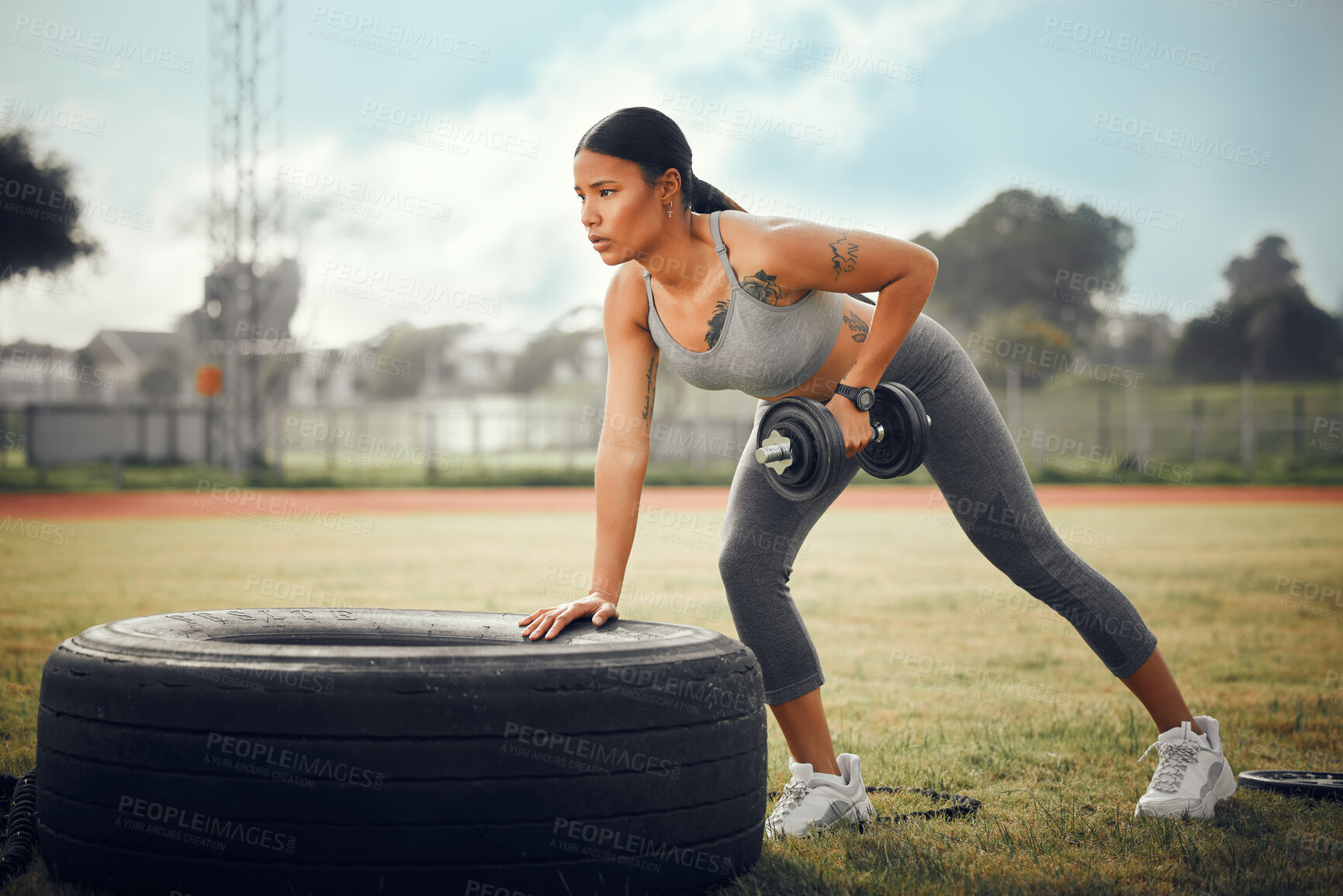 Buy stock photo Full length shot of an attractive young female athlete exercising with dumbbells outdoors