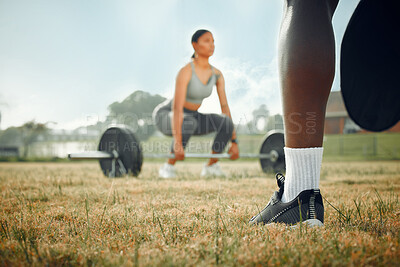 Buy stock photo Closeup shot of an unrecognizable male athlete standing outside while a woman exercises with weights in the background