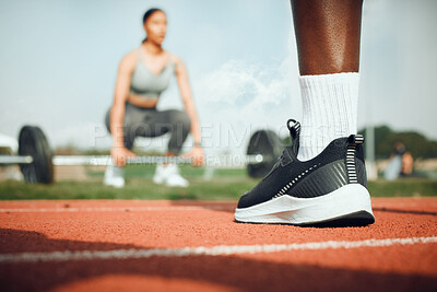 Buy stock photo Closeup shot of an unrecognizable male athlete standing outside while a woman exercises with weights in the background