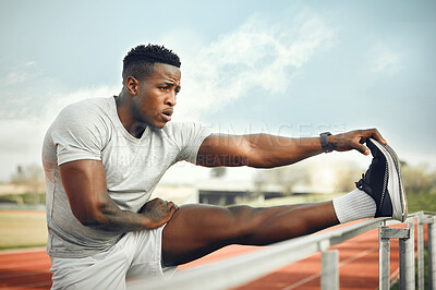 Buy stock photo Cropped shot of a handsome young male athlete warming up before starting his outdoor workout