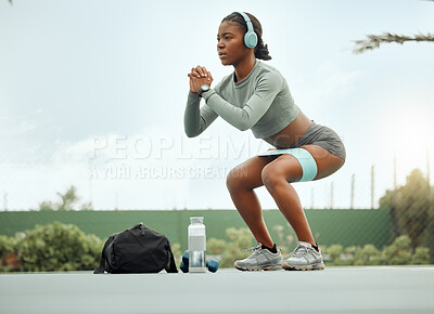 Buy stock photo Full length shot of an attractive young female athlete doing squats as part of her workout on a sports court