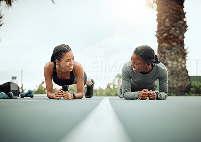 Buy stock photo Full length shot of two attractive young female athletes planking while working out on a sports court