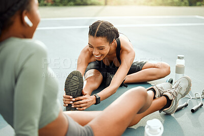 Buy stock photo Cropped shot of two attractive young female athletes warming up outside before beginning their workout