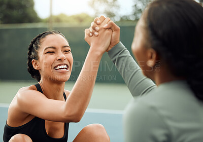 Buy stock photo Cropped shot of two attractive young female athletes cheering while exercising outside on a sports court