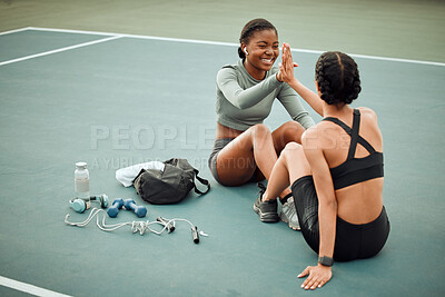 Buy stock photo Full length shot of two attractive young female athletes high fiving while exercising outside on a sports court