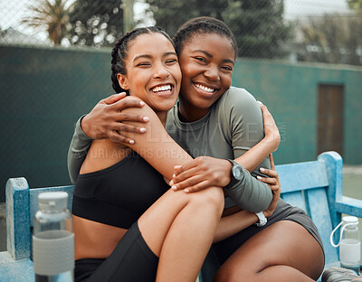 Buy stock photo Cropped portrait of two attractive young female athletes embracing while sitting on a bench outside during their workout