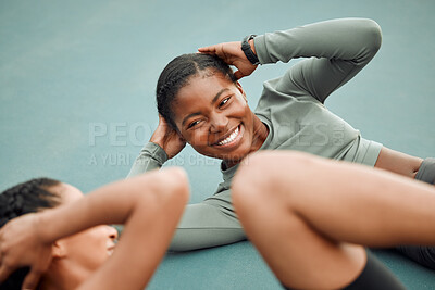 Buy stock photo High angle shot of two attractive young female athletes doing leg raises during their workout on a sports court