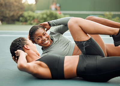 Buy stock photo Cropped shot of two attractive young female athletes doing leg raises during their workout on a sports court