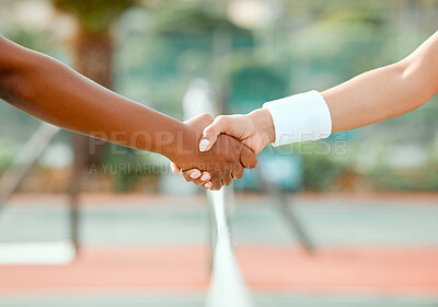 Buy stock photo Shot of two sporty women shaking hands while playing tennis together on a court
