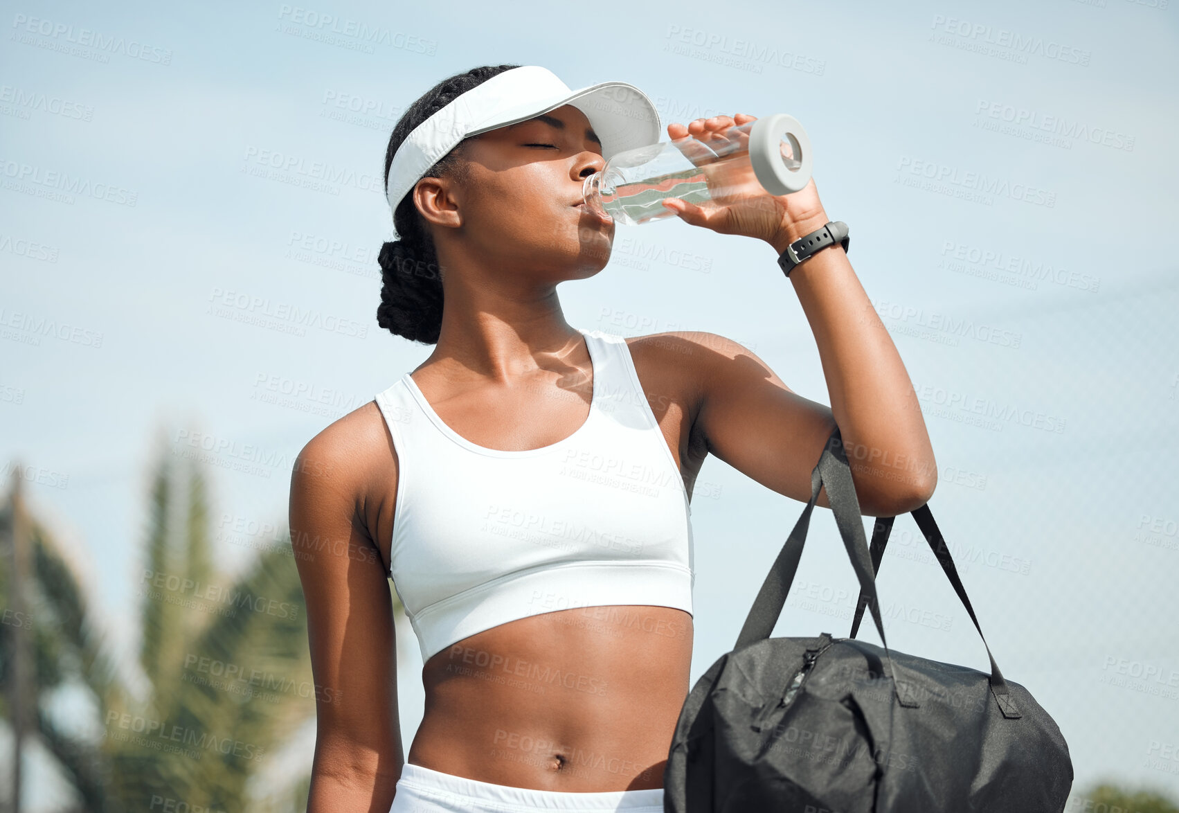 Buy stock photo Tennis, drinking water and black woman on court, sports and fitness with nutrition, wellness and workout. African person, outdoor and athlete with bottle racket and training with break and healthy