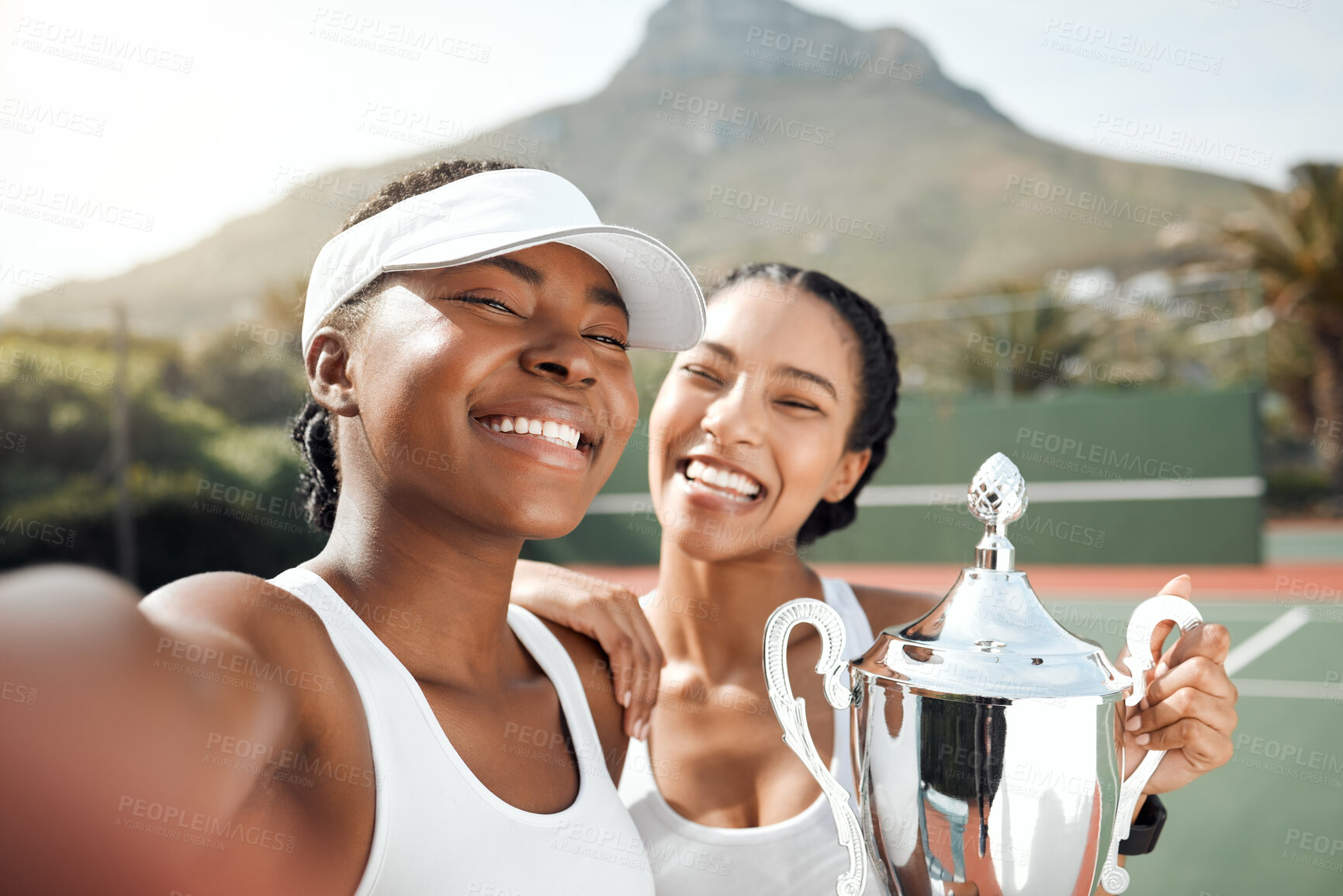 Buy stock photo Portrait of two sporty young women taking selfies with a trophy on a tennis court