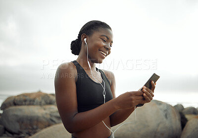 Buy stock photo Shot of a young woman listening to music during a workout