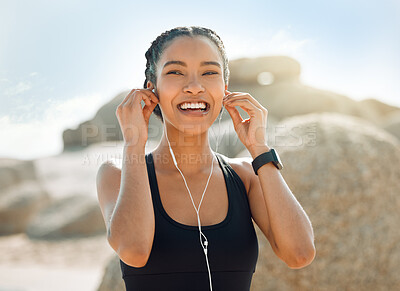 Buy stock photo Happy woman with earphones, fitness at the beach and listening to music for motivation and workout outdoor. Exercise, health and smile, female athlete streaming online with radio and audio in nature