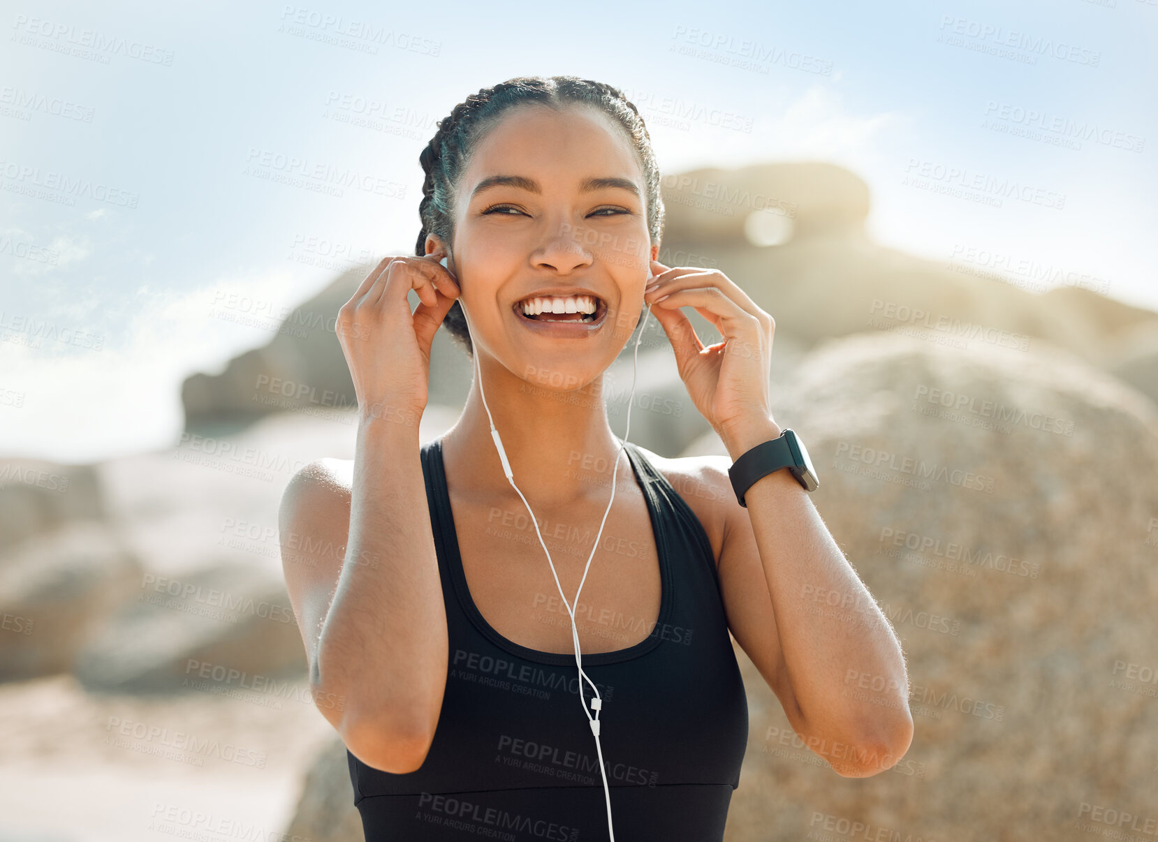 Buy stock photo Happy woman with earphones, fitness at the beach and listening to music for motivation and workout outdoor. Exercise, health and smile, female athlete streaming online with radio and audio in nature