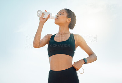 Buy stock photo Shot of a young woman re hydrating during a workout