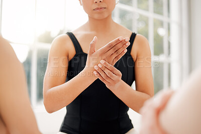 Buy stock photo Cropped shot of a ballet dancer rubbing her hand during her dance routine