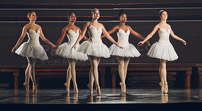 Buy stock photo Shot of a group of ballet dancers practicing a routine on a stage