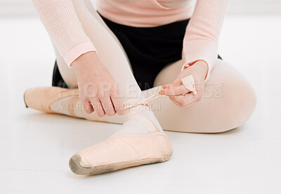Buy stock photo Cropped shot of an unrecognizable ballet dancer fitting her shoes on before practice