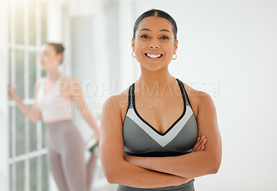Buy stock photo Shot of a fit young woman smiling while standing with her arms crossed