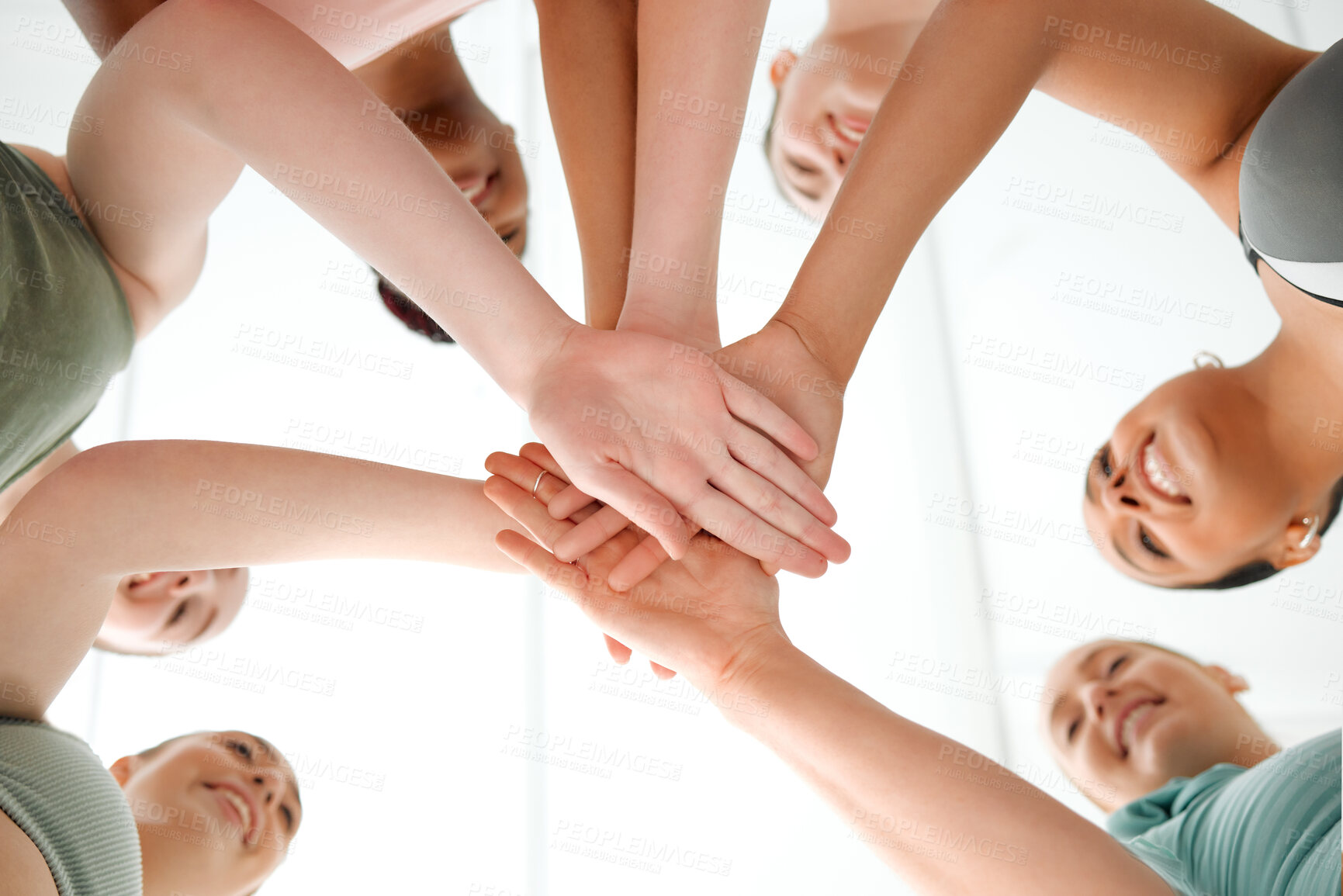 Buy stock photo Shot of a group of fit young women joining their hands in a huddle