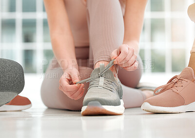 Buy stock photo Shot of an unrecognizable woman tying her shoelaces
