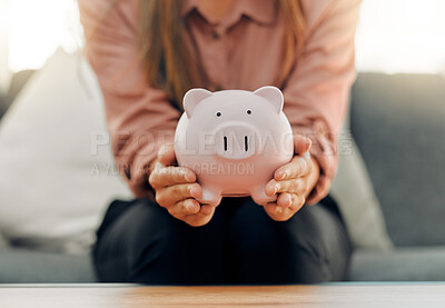 Buy stock photo Shot of a unrecognizable female holding a piggy bank at home