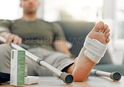 Buy stock photo Shot of a unrecognizable man relaxing his foot on a table at home