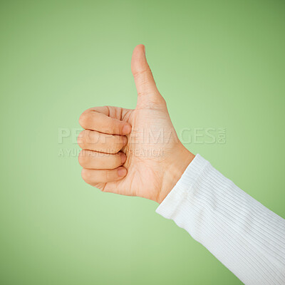 Buy stock photo Shot of an unrecognizable woman showing a thumbs up against a green background
