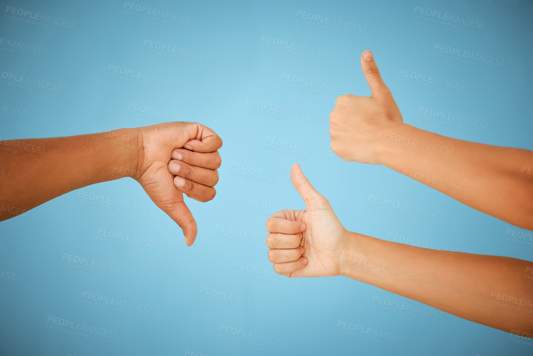 Buy stock photo Shot of unrecognizable people showing the thumbs up and thumbs down against a blue background