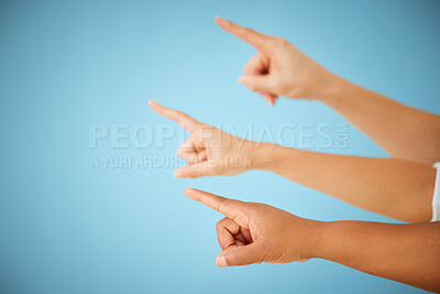 Buy stock photo Shot of an unrecognizable group of people pointing in the same direction against a blue background