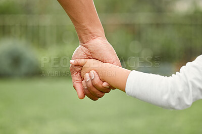 Buy stock photo Shot of a little girl holding her father's hand while going for a walk in the park