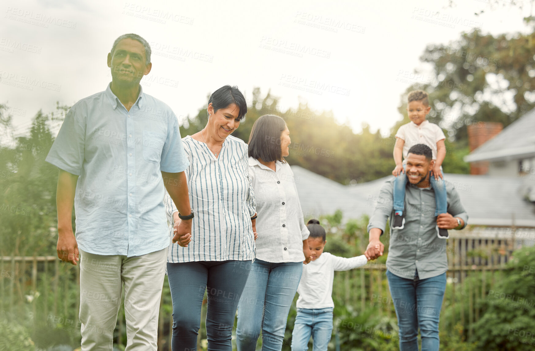 Buy stock photo Smile, big family and holding hands for walking outdoor with child on father shoulders, love and bonding. Happy, grandparents and children with care, support and playful, trust and explore of garden