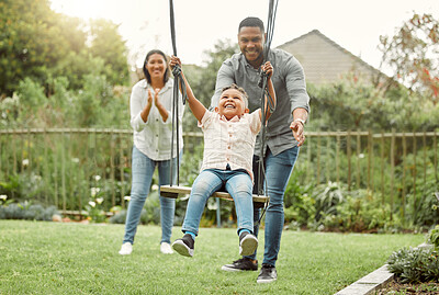 Buy stock photo Shot of parents playing with their son on the swing outside
