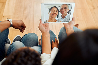 Buy stock photo Rearview shot of a family calling their parents and sharing a video call on the sofa at home