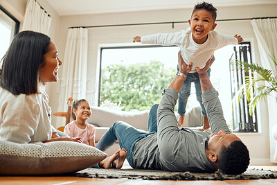 Buy stock photo Family, father lifting son and playing in living room with fun and mother with daughter bonding at home together. Happy people with love, care and carefree, airplane and parents relax with kids 