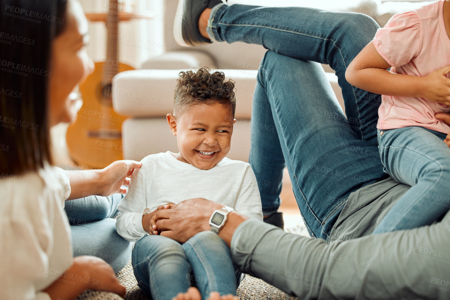 Buy stock photo Cropped shot of a young family playing together on the lounge floor at home