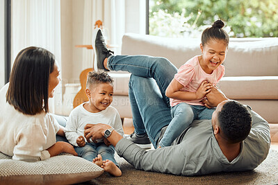 Buy stock photo Happy family, laughing and playing on floor in living room for fun bonding relationship together at home. Father, mother and children enjoying funny play time, laugh or holiday weekend in the house