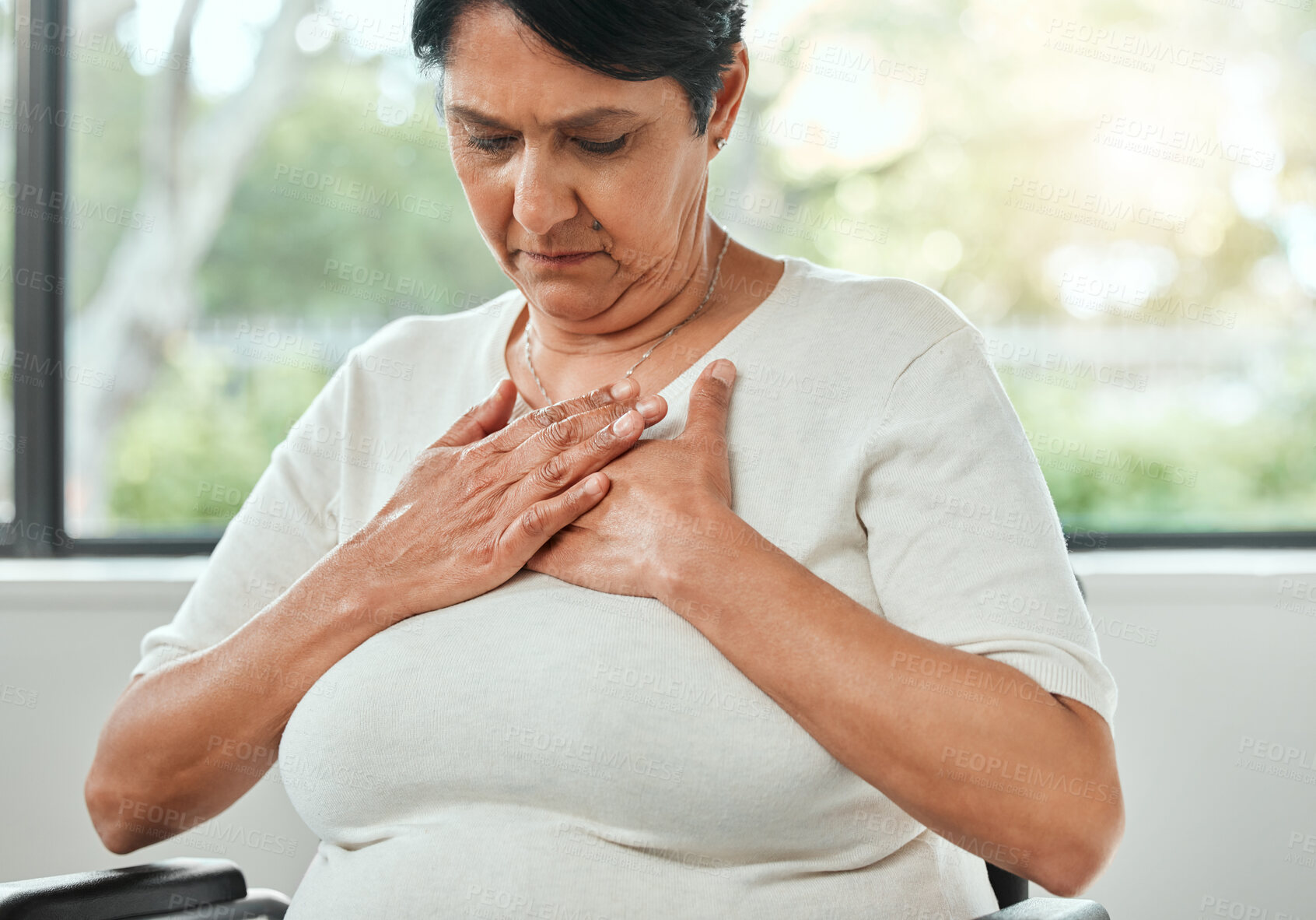 Buy stock photo Home, chest pain and senior woman with disability for heart attack, breathing problem and anxiety. House, wheelchair and elderly person in retirement with asthma, cardiac arrest and medical emergency