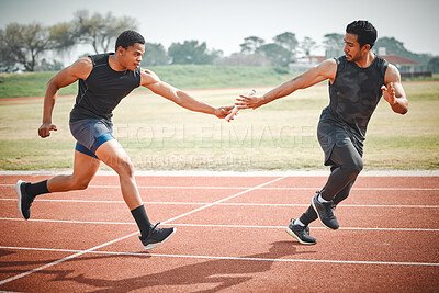 Buy stock photo Full length shot of a handsome young male athlete grabbing a baton from his teammate during a relay race