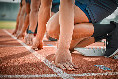 Buy stock photo Cropped shot of three unrecognizable male athletes starting their race on a track